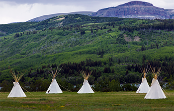Teepees landscape with mountain range background glacier national park glacier county - stock photo by Ingram via Freepik.com